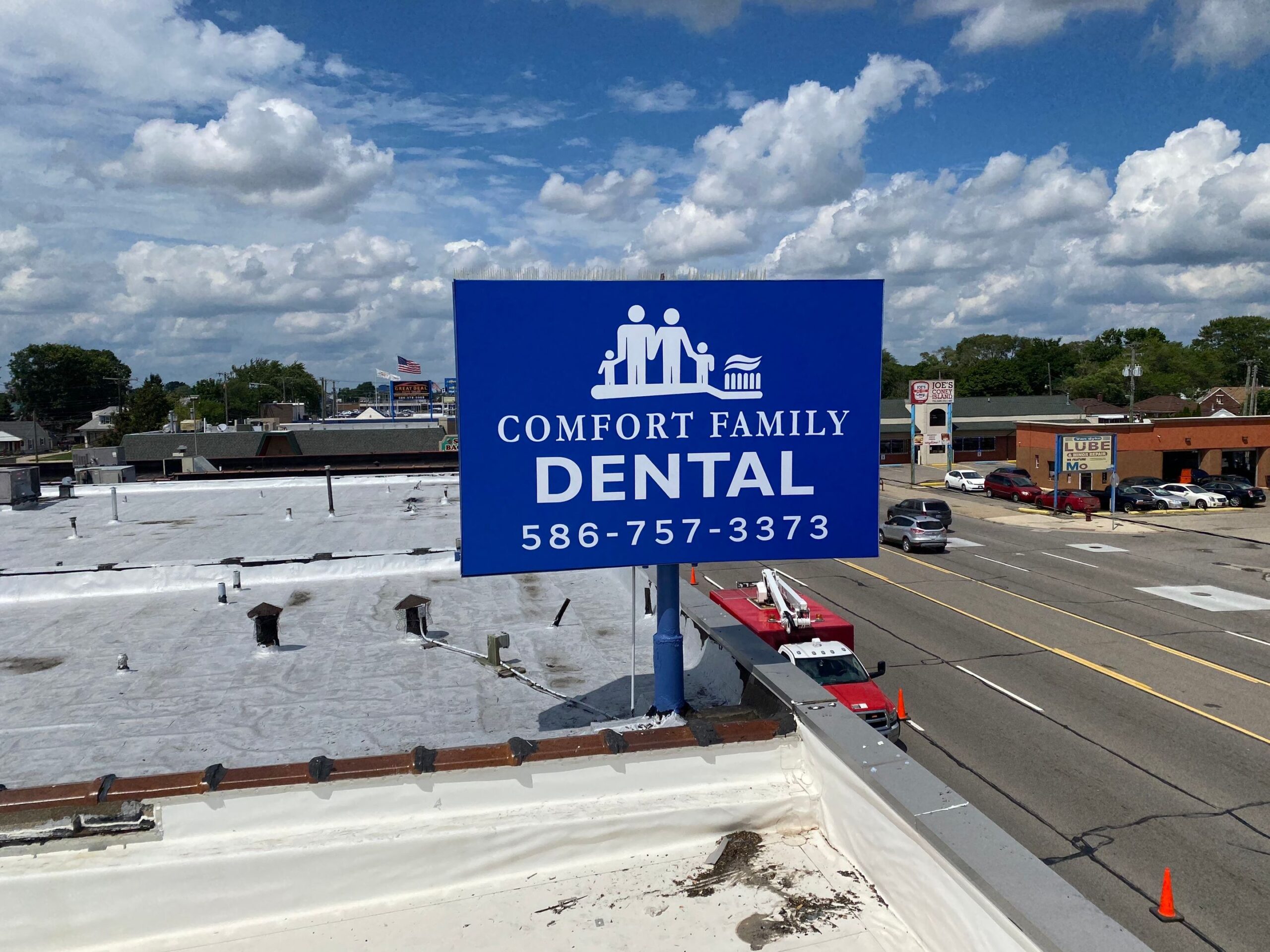blue pylon sign for Comfort Family Dental, installed on roof