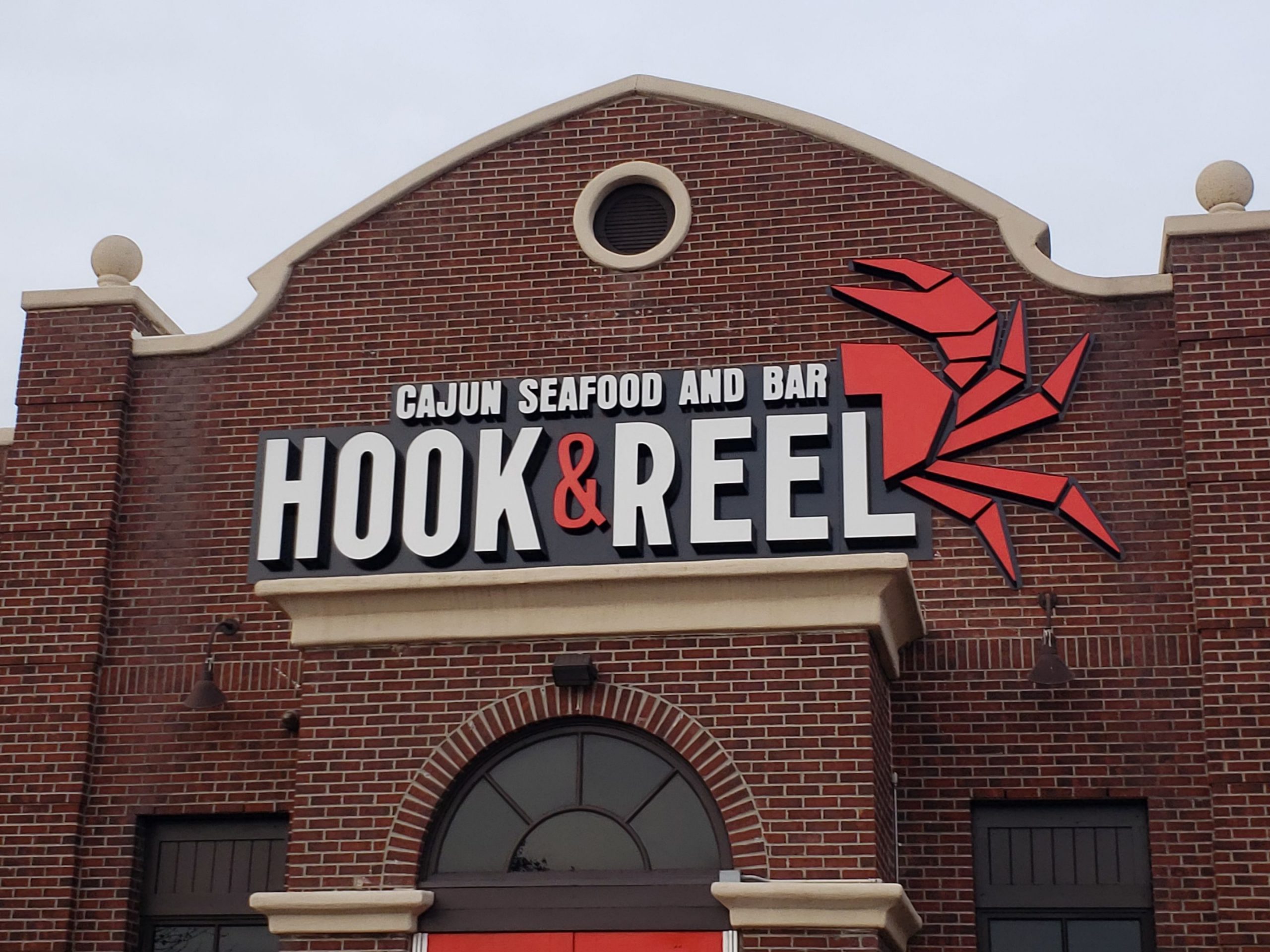 hook and reel seafood restaurant channel letter and logo installed on brick building